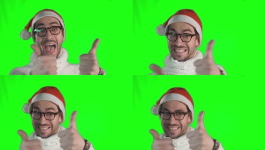 帅气的年轻人戴着时尚的眼镜和圣诞老人的帽子，对着镜头竖起大拇指，微笑着高清在线视频素材下载