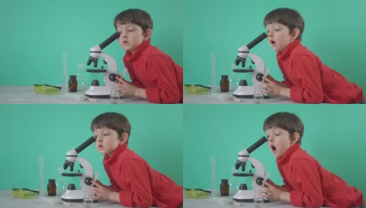 小男孩在用显微镜做生物化学研究高清在线视频素材下载