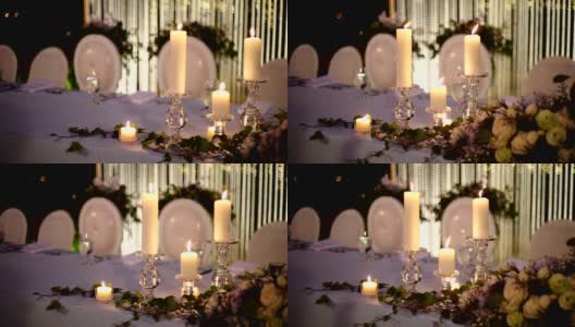 浪漫的户外婚庆桌，桌上摆放鲜花和蜡烛，背景模糊。高清在线视频素材下载
