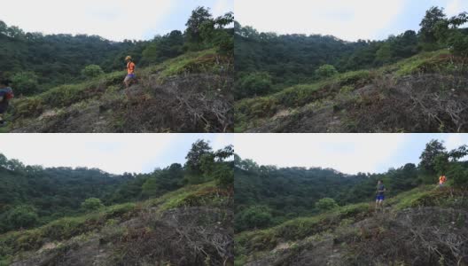 两名女子跑步者在热带森林的山坡上跑下坡，慢动作高清在线视频素材下载