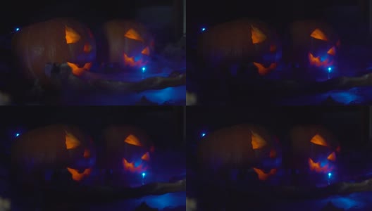 万圣节的时候，两个南瓜里面有一张可怕的脸在发光，晚上在黑暗中烟雾从左边传到右边。高清在线视频素材下载