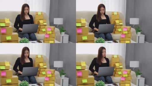女企业家使用笔记本电脑，并检查准备递送给客户在家办公的包裹盒子，(中小企业业务)高清在线视频素材下载