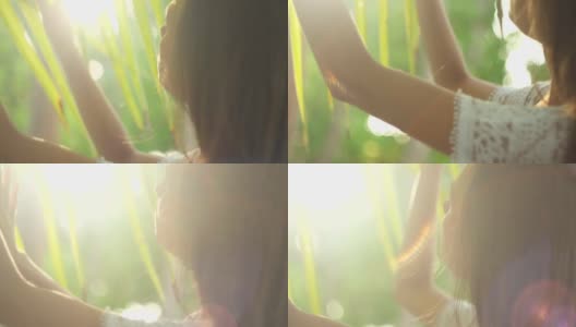 年轻女子触摸棕榈叶。美丽的太阳眩光。与自然统一。天堂岛。热带地区。马尔代夫。高清在线视频素材下载