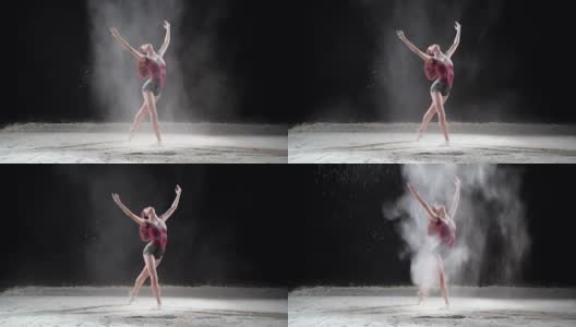 美丽的芭蕾舞演员在演播室与粉雪跳舞。慢动作高清在线视频素材下载