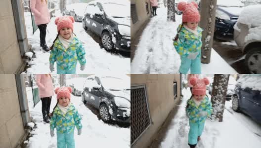 可爱的蹒跚学步的孩子在雪中奔跑，而母亲正在等待高清在线视频素材下载