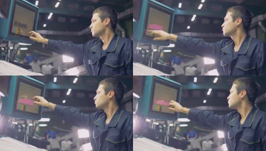 在工厂使用电脑操作机器的工人。高清在线视频素材下载