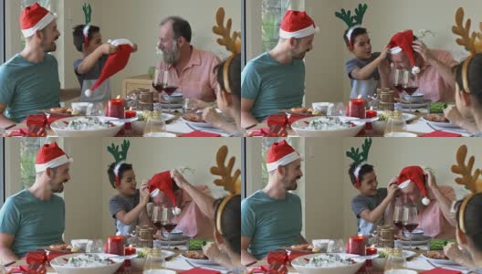 孙子在圣诞餐厅给爷爷送了一顶圣诞帽高清在线视频素材下载