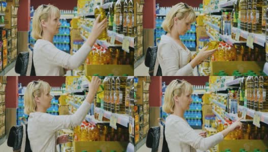 年轻女子在超市看一瓶橄榄油或其他油高清在线视频素材下载