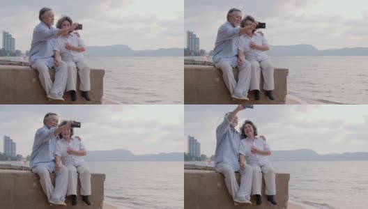 资深亚洲夫妇使用智能手机自拍在海滩上与幸福的情感在一起。有生活方式、退休和科技观念的人。高清在线视频素材下载