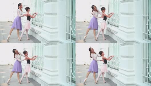 在泰国一个阳光明媚的日子里，在曼谷当地的街道上，一名亚洲青少年芭蕾舞演员在担任芭蕾舞老师时，按照年轻女芭蕾舞师的建议练习芭蕾舞。概念活泼的年轻妇女和孩子在周末的活动。高清在线视频素材下载