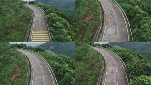 航拍健身女跑步者在山顶步道上奔跑，在山脚下远处的现代城市，慢镜头高清在线视频素材下载