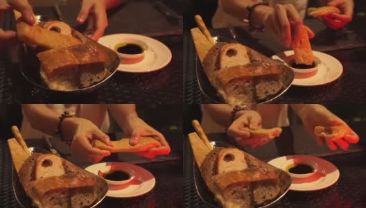 手蘸新鲜出炉的面包在橄榄油和醋意大利餐厅高清在线视频素材下载