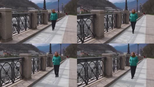 在高地小镇上孤独行走的老妇人高清在线视频素材下载