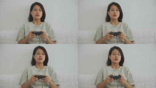 亚洲年轻女子玩电子游戏手柄高清在线视频素材下载