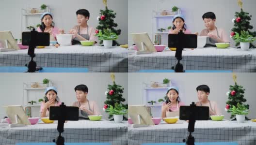 圣诞节期间，亚洲孩子们在家里拍摄饼干烹饪视频制作视频，或者在家里一起拍TikTok，这是新一代概念的时尚生活方式。高清在线视频素材下载
