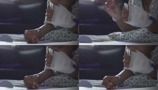 特写的童年包扎的手与颜料彩色铅笔在一张纸上医院。治疗室实时拍摄。年轻病人的放松时间。高清在线视频素材下载