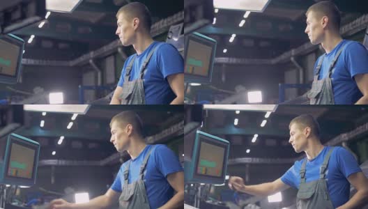 在工厂生产线上使用电脑触摸屏的男性工人。高清在线视频素材下载