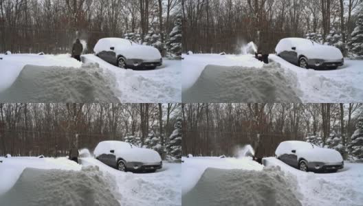 一场冬季暴风雪过后，一名男子正在清理他被雪覆盖的汽车周围的车道。高清在线视频素材下载