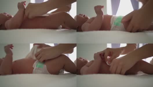 亚洲母亲在床上给孩子换尿布高清在线视频素材下载