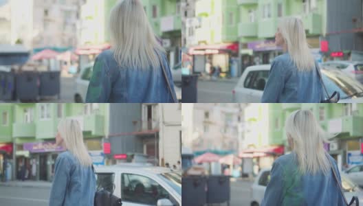 身着牛仔夹克的年轻时尚女子的背影走过市中心高清在线视频素材下载