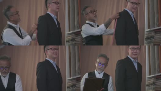 亚洲华人成熟男子裁缝与脸胡茬测量他的客户的身体尺寸，为新的运动上衣制作高清在线视频素材下载