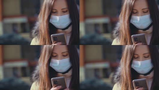 近距离观察，一名妇女戴着医用口罩，在城市街道上用手机发送信息，以防止空气污染和冠状病毒感染高清在线视频素材下载