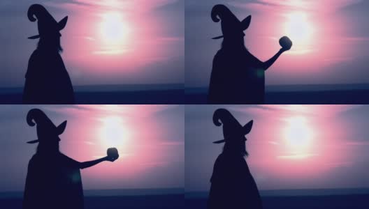 一个穿着女巫服装的女人举起一个有魔力的苹果高清在线视频素材下载