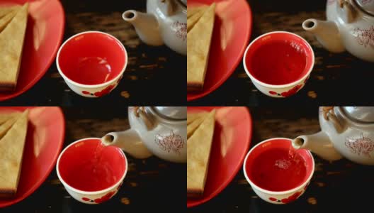 把茶从茶壶里倒进碗里高清在线视频素材下载