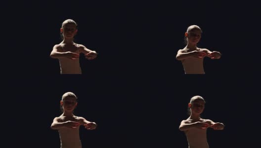 一个年轻的芭蕾舞者在黑色背景上摆姿势高清在线视频素材下载