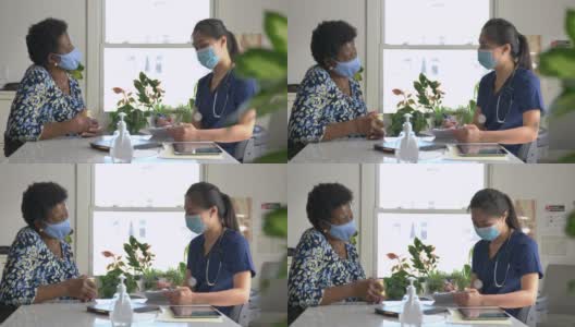 女医生与年长病人在门诊预约时戴口罩高清在线视频素材下载