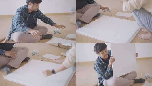 亚洲男人和女人在地板上讨论自己动手做的木板和工具高清在线视频素材下载