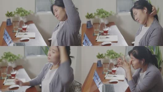 一位亚洲妇女在家工作时伸展身体。高清在线视频素材下载