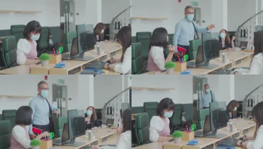 工作中的亚洲华人高级同事戴着口罩回到办公室，早上在办公室互相问候高清在线视频素材下载