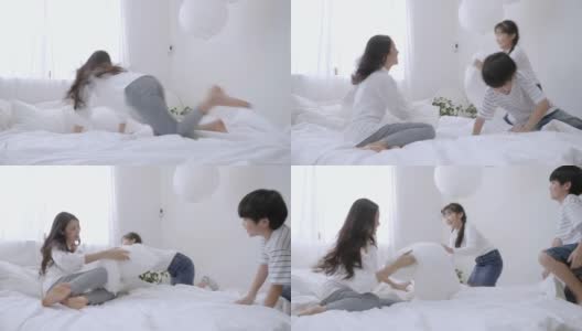 亚洲妈妈和孩子在卧室的白色床垫上玩耍高清在线视频素材下载