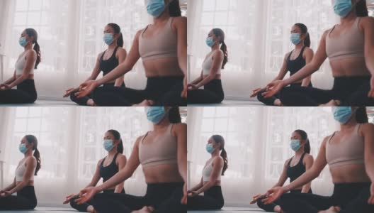 一群戴着医用口罩在健身房做瑜伽的亚洲女性。高清在线视频素材下载
