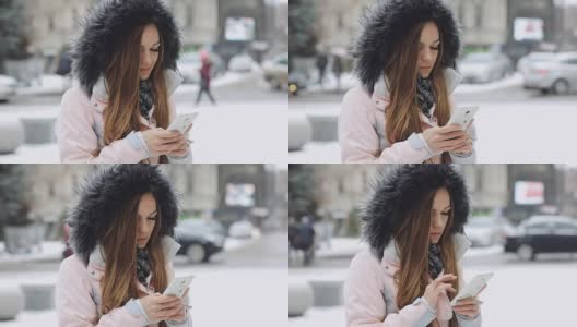 一名年轻女子在冬日下雪天使用智能手机高清在线视频素材下载