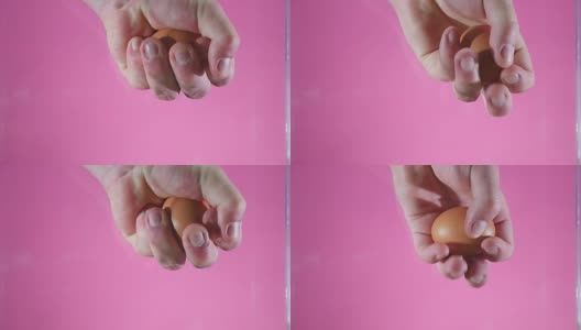 一个男人的手握着并试图捏碎一个鸡蛋高清在线视频素材下载