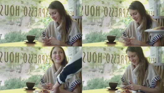 一个年轻女子坐在咖啡馆里，一边喝着咖啡，一边发短信高清在线视频素材下载