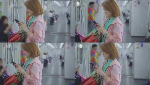 年轻女子在乘坐地铁时使用智能手机，慢镜头高清在线视频素材下载