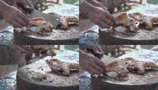 一只手把烤鸡剁在剁好的木块上，皮肤油腻，是健康食品高清在线视频素材下载