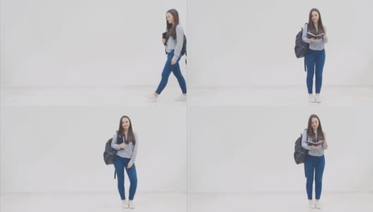 一个亚洲女学生带着背包出现在白色背景上，打开一本黑色的书，看着它，合上，摆出姿势。高清在线视频素材下载