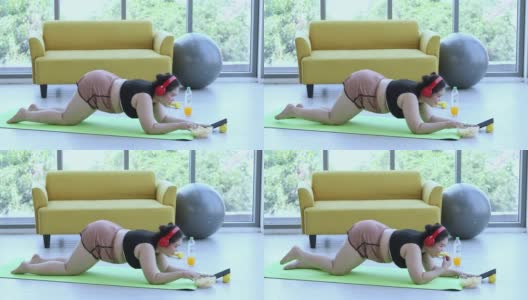 亚洲体型较大的女性和教练在健身课上锻炼，教练建议肥胖女性进行运动减肥高清在线视频素材下载