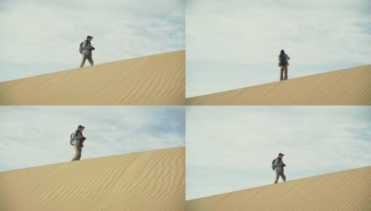 一个亚洲人在多云的天空下走在沙丘上高清在线视频素材下载