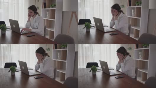 一个沮丧和悲伤的女人在家里用笔记本电脑工作高清在线视频素材下载