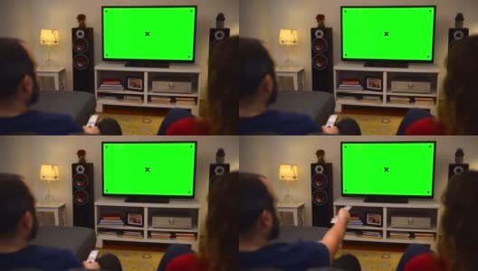 一对夫妇在家里看彩色键绿屏电视高清在线视频素材下载