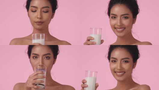 美丽的亚洲女孩喝牛奶。拿着牛奶杯的漂亮女孩趁机解毒。饮料、保健、食品饮料的概念。高清在线视频素材下载