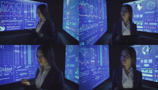 在黑暗的实验室里用平板电脑和显示器工作的女商人高清在线视频素材下载