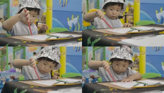 小男孩正在桌子上画画。高清在线视频素材下载