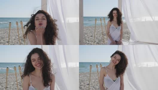 肖像美丽的女孩在海滩上，快乐的女人卷着头发，夏天度假的女人在海边，女性美丽的脸微笑高清在线视频素材下载