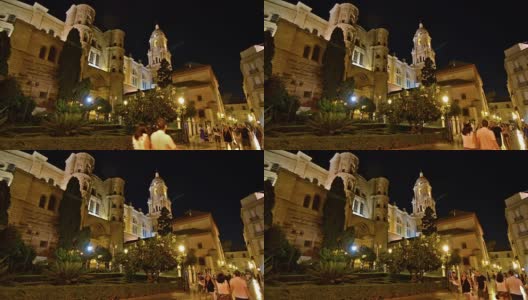 西班牙马拉加。2017年10月左右。人们在夜间行走。背景是大教堂。高清在线视频素材下载